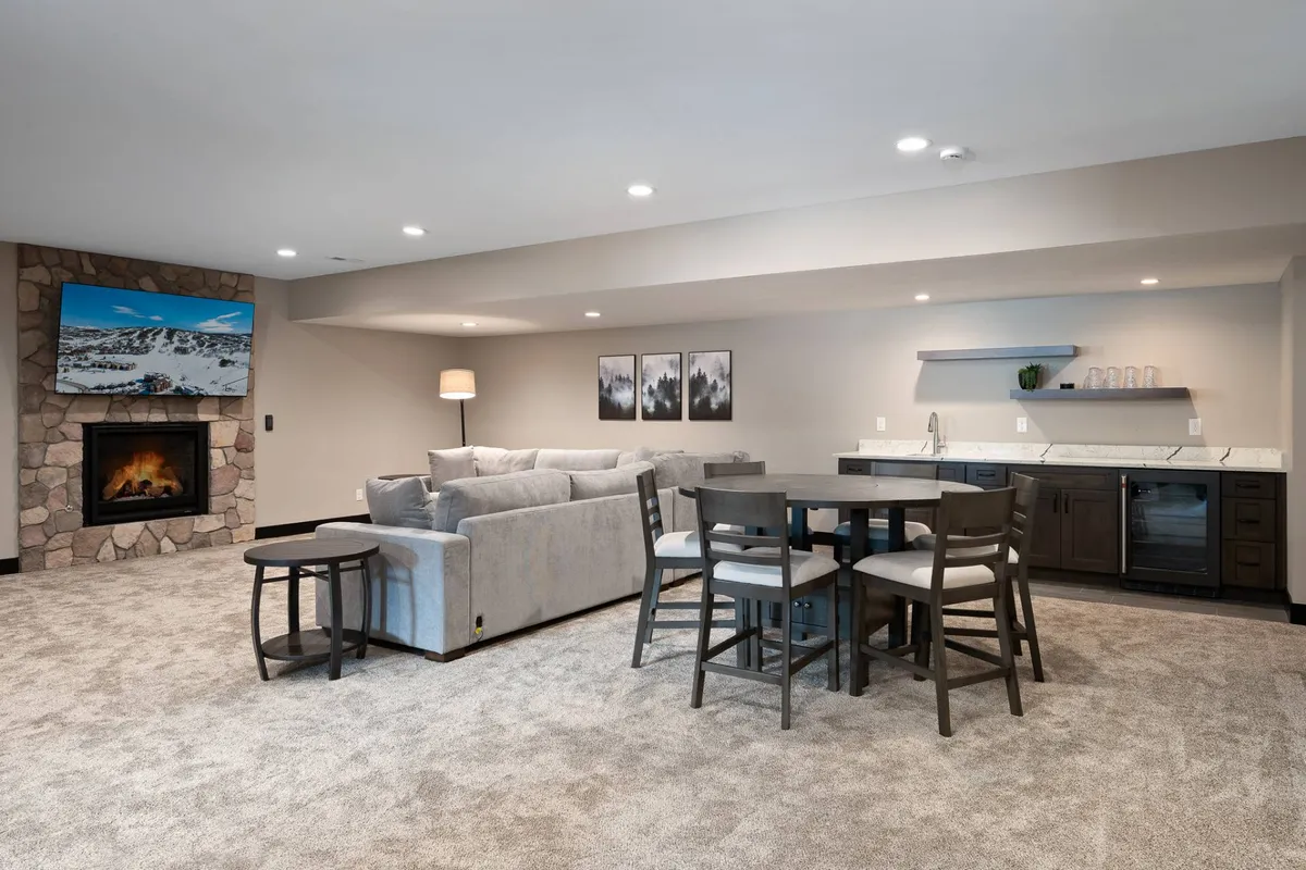 A comfortable living area is shown with a plush sofa, a warm fireplace, a family dining table, and a television, evoking a sense of relaxation and togetherness. The scene suggests memorable moments such as game nights, holiday celebrations, and unwinding after a day at the resort.